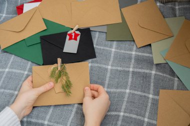 Geleneksel 24 günlük takvim Noel tatilinden önce. Zarflardaki numaralar Plastiksiz sıfır atık sürdürülebilir dekorasyon. Kışın ev yapımı Katolik Noel geri sayımı gelenekleri