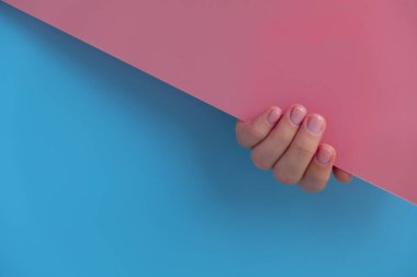 Pastel yumuşaklığı, mavi arka planda manikürlü tırnaklar. Pastel paletin renginde yeni manikürünü gösteren bir kadın. Basitlik dekoru Taze bahar titreşimleri Toprak renginde nötr tonlar tasarım