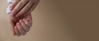 Tarafsız bej arka planda yumuşak manikürlü tırnaklar. Pastel paletin renginde yeni manikürünü gösteren bir kadın. Basitlik dekoru Taze bahar titreşimleri Toprak renginde nötr tonlar tasarım