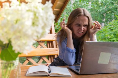 Stressed Young woman freelancer working online using laptop outdoors in garden. Emotional stress anxiety, homelife difficulties. Online meeting education. clipart