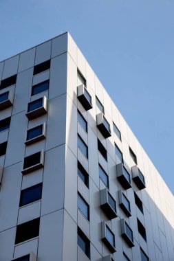 Kare pencereli modern beyaz bina. Çok katlı bir apartman. Minimalist stil apartman dairesi. Modern ofis binası cepheleri. Dış doku kalıbı. Görsel sanat