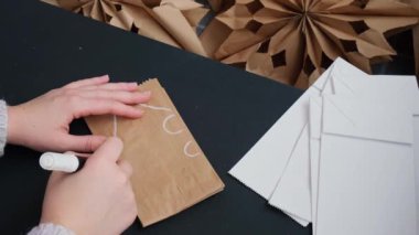 Noel yıldızı ve yeni yıl arifesi için hazırlanma süreci. Üç boyutlu el çantası kar tanelerini boyamış. Sorumlu ekolojik sıfır atık el yapımı dekorasyon. Çocuk hobisi ev dekorasyonu