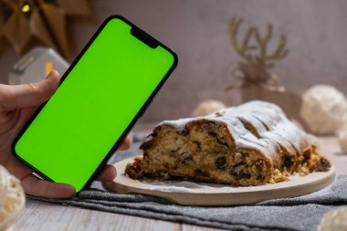 Noel ışıkları ve dekorasyonuyla çalınmış Noel. Yeşil ekran krom anahtar uygulama web sitesi reklamlı akıllı telefon şablonu oluşturur. Geleneksel şekerli meyveli somun dondurma.