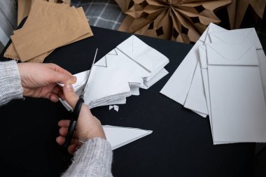 Noel yıldızı ve yeni yıl arifesi için hazırlanma süreci. Üç boyutlu el çantası kar tanelerini boyamış. Sorumlu ekolojik sıfır atık el yapımı dekorasyon. Çocuk hobisi ev dekorasyonu