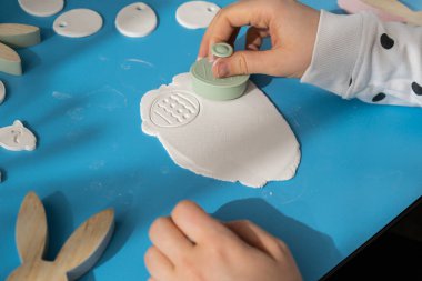 Atölye kesim figürleri Yaratıcı, Paskalya tatili için beyaz hava kuru kilini kullanıyor. Parmakları kapsayan hobi aktivitesi yaratmak. DIY Modern Sanat Sanatı 