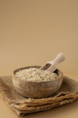 Tarafsız bej arka planda esmer pirinç kopyalama alanı. Tam hecelenmiş tahıl türü. Yüksek proteinli lif zengini vejetaryen gıda bileşeni. Glütensiz süper yiyecek sağlıklı beslenme alternatifi