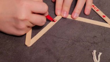 Dondurma çubuklarına dilek yazmak Noel yıldızı Sürdürülebilir Hazırlık Diy süreci el yapımı dekorasyon yapıyor. Çocuklar için adım adım etkinlik. Ayrıcalıklı ve sorumluluk sahibi stres atma tatili