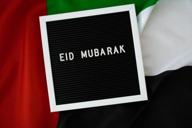 İleti EID MUBARAK - Arka plan konseptinde BAE bayrağı sallayarak mutlu tatiller. Tebrik kartı reklamı. Müslüman Ramazan Bayramı kutsanmış ay resmi bayramıdır. Vatanseverlik