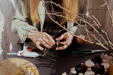 Yumurta kabuğundan Paskalya bayramı süsü yapan tanınmamış bir kadın. Bunu kendin adım adım kendin mi yaptın? Hazırlık tatili.