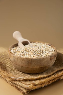 Tarafsız bej arka planda inci arpa. Tam hecelenmiş tahıl türü. Yüksek proteinli lif zengini vejetaryen gıda bileşeni. Glütensiz süper yiyecekler sağlıklı beslenme alternatifleri 