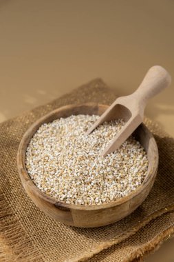 Tarafsız bej arka planda güzel bir arpa. Tam hecelenmiş tahıl türü. Yüksek proteinli lif zengini vejetaryen gıda bileşeni. Glütensiz süper yiyecekler sağlıklı beslenme alternatifleri