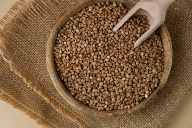 Tarafsız bej arka plan fotokopi alanında çiğ karabuğday lapası. Tam hecelenmiş tahıl türü. Yüksek proteinli lif zengini vejetaryen gıda bileşeni. Glütensiz süper yiyecek sağlıklı beslenme