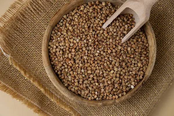 Tarafsız bej arka plan fotokopi alanında çiğ karabuğday lapası. Tam hecelenmiş tahıl türü. Yüksek proteinli lif zengini vejetaryen gıda bileşeni. Glütensiz süper yiyecek sağlıklı beslenme