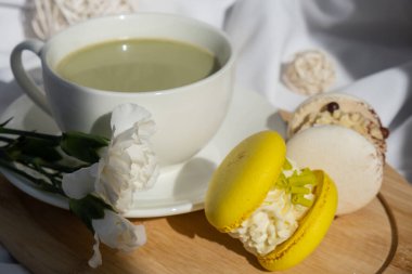 Besin zengini kibritçi içeceği. Yatakta ahşap tepside taze çiçeklerle modadan yapılmış makarna tatlısı. Günaydın güzel kahvaltı hediyesi fikri. Canlı yaratıcı renkler. Doğal enerji çay verir.