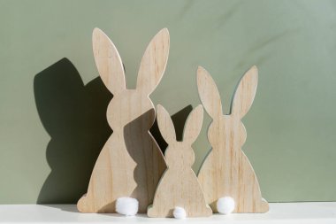 Asgari yaratıcı Paskalya konsepti. Yeşil arka planda sembolik çatı altında iki Paskalya tavşanı. Paskalya tatilini ailenle birlikte evde kutla. Poster ya da tebrik kartı. Yüksek kalite fotoğraf