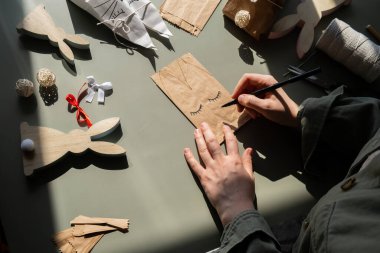 Kadınların Paskalya için gizli paskalya hediye paketi düzenleme işlemleri. Çocuklar için el yapımı el yapımı kağıt hediye kullanma kılavuzu aktivitesi. Sıfır atık çevre dostu