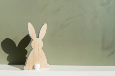 Asgari yaratıcı Paskalya konsepti. Yeşil arka planda sembolik çatı altında iki Paskalya tavşanı. Paskalya tatilini ailenle birlikte evde kutla. Poster ya da tebrik kartı. Yüksek kalite fotoğraf