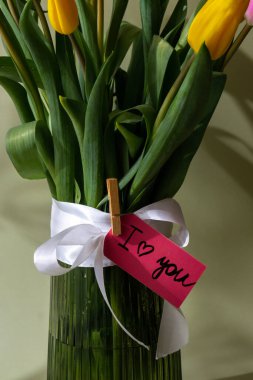 Pastel yeşil arka planda vazoda renkli lalelerden oluşan kağıt kart buketini seviyorum. Tebrik kartı için alanı kopyala. Tatil çiçekleri ilkbahar atmosferi