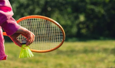 Tahta badminton raketleri ve oyuncak horozlarla oynayan tanınmayan bir kadın. Uzay yaz aktivitelerini kopyala. Konaklama boş zamanı