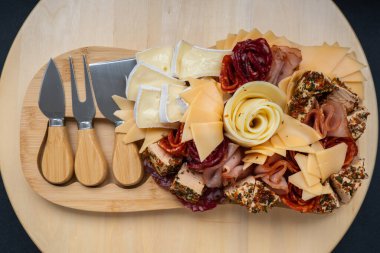 Peynir ve et şarküteri tahtası. Hediye hediyesi, öğle yemeği tabağı. Görsel olarak en az çaba gerektiren atıştırmalıklar. Özel peynir bıçaklarıyla basit bir yemek hazırlama. Tahta.