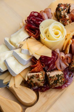 Peynir ve et şarküteri tahtası. Hediye hediyesi, öğle yemeği tabağı. Görsel olarak en az çaba gerektiren atıştırmalıklar. Özel peynir bıçaklarıyla basit bir yemek hazırlama. Tahta.