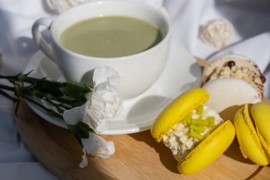 Besin zengini kibritçi içeceği. Yatakta ahşap tepside taze çiçeklerle modadan yapılmış makarna tatlısı. Günaydın güzel kahvaltı hediyesi fikri. Canlı yaratıcı renkler. Doğal enerji çay verir.