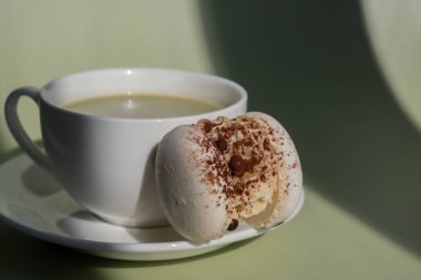 Pastel arka planda beyaz kakao badem kurabiyeli yeşil latte kibriti ve yaratıcı gölgeler. Tatil kahvaltısı çay içeceği kavramı. Samimi minimalist süper yiyecekler enerjik renkler sağlıklı