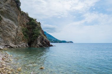 Karadağ 'ın Budva kenti yakınlarındaki katmanlı kayalar arasında güzel kayalar ve parlak turkuaz su bulunuyor. Adriyatik Denizi 'ndeki tropik yaz manzaralı egzotik plajlar. Tatil fikri. 