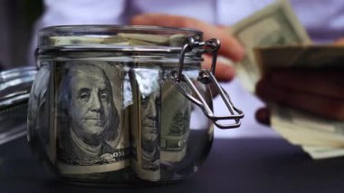 Dolar banknotu cam kavanozda para biriktiriyor. Tanınmayan Adam Orta Yol Tüketim ve Ekonomi Para Bahşişi Topluyor İş Finans Görüntüleri