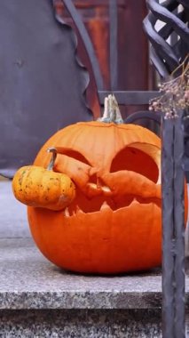 Sonbaharda dikey Sonbahar Balkabağı Jack Lantern dışarıda. Şükran Günü ya da Cadılar Bayramı için. Evin girişi şenlikli mevsimlik dekorasyonda. Atmosfer estetiği
