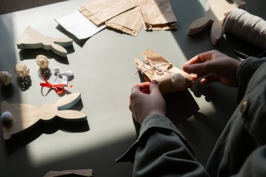 El yapımı Paskalya hediye paketi tavşanı yapma talimatı. El işi kağıttan sürdürülebilir malzeme süslemeleri. Kadın elleri el yapımı el yapımı hediyeler yaratıyor. Paskalya kutlaması