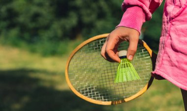 Elinde tahta Badminton raketi ve oyuncak horoz tutan bir kadın. Eğlence ve temiz hava dışında. Sağlıklı yaşam tarzı doğal bağlantı sporu yaz aktiviteleri. Stres atma hobisi sağlık hizmetleri