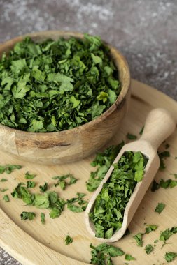 Ahşap kasede tahta kaşıkla kuru maydanoz baharatı. Yemek pişirmek için ev yapımı otlar ve baharatlar. Taze kurutulmuş aromatik doğal gıda malzemeleri. Boşluğu kopyala 