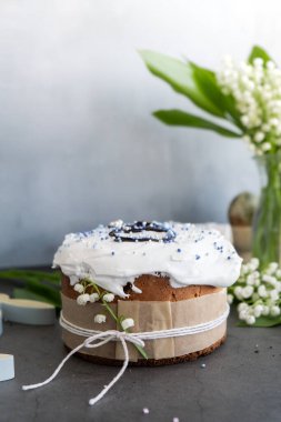 Ev yapımı Paskalya pastası kremalı ve yaratıcı dekorasyon yiyecekli panettone. Hıristiyan bayramı için hazırlık Kulich. Arka planda Paskalya yumurtası ve tavşan var. 