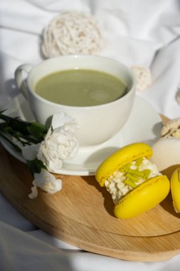 Besin zengini kibritçi içeceği. Yatakta ahşap tepside taze çiçeklerle modadan yapılmış makarna tatlısı. Günaydın güzel kahvaltı hediyesi fikri. Canlı yaratıcı renkler. Doğal enerji çay verir.