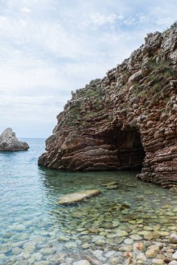 Karadağ 'ın Budva kenti yakınlarındaki katmanlı kayalar arasında güzel kayalar ve parlak turkuaz su bulunuyor. Adriyatik Denizi 'ndeki tropik yaz manzaralı egzotik plajlar. Tatil fikri. 