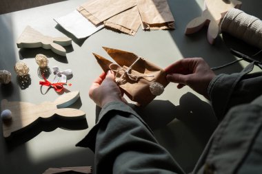 El yapımı Paskalya hediye paketi tavşanı yapma talimatı. El işi kağıttan sürdürülebilir malzeme süslemeleri. Kadın elleri el yapımı el yapımı hediyeler yaratıyor. Paskalya kutlaması