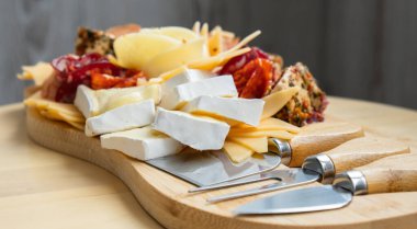 Tahta şarküteri peyniri bayram tatili fikri. Akşam yemeği için başlangıç tabağı ve şarap. İtalyan aperatifleri ya da gurme yemeklerle hazırlanmış antipasto. Açık büfe parti konsepti