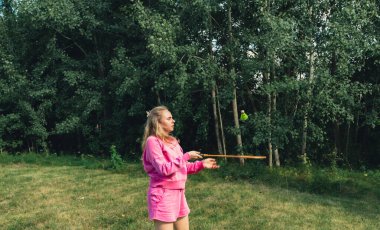 Kadın, yeşil çimlerde Badminton raketi ve mekik horozu oynuyor. Eğlence ve temiz hava dışında. Sağlıklı yaşam tarzı doğal bağlantı sporu yaz aktiviteleri. Stres atma hobisi sağlık hizmetleri