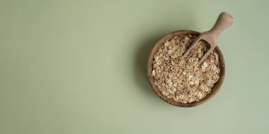 Yeşil arka planda çiğ yulaf lapası kopyalama alanı. Tam hecelenmiş tahıl türü. Yüksek proteinli lif zengini vejetaryen gıda bileşeni. Glütensiz süper yiyecek sağlıklı beslenme alternatifi