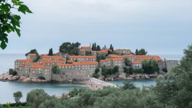 Sveti Stefan 'ın Budva yakınlarındaki Karadağ' daki özel adası. Adriyatik Denizi kıyısı seyahat tatil gezisi fikri. Turizm deneyimlerinden kaçma kavramı. Doğa güdümlü manzara. Gezgin şehvet titreşimleri.