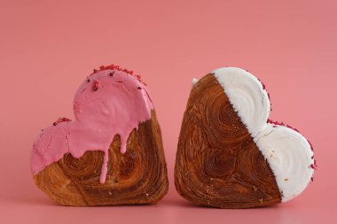 Kalp, pembe arka planda fotokopi alanı olan iki ay çöreği şekillendirdi. Puf puf yeni moda tatlı pastanesi. Kremalı hamur deneyi 