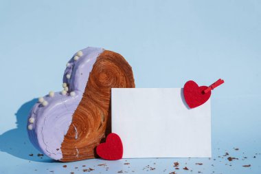 Boş kağıt kart şablonu, mavi arkaplanlı ve fotokopi alanı olan Kalp şeklinde yaban mersini aromalı kruvasan. Puf puf yeni moda tatlı pastanesi. Kremalı hamur deneyi 