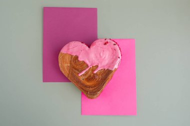 İki renkli tebrik kartı Sevgililer Günü Lezzetli taze kruvasanlar üzerine renkli Ganache aromalı. Eşsiz kalp şekilli fırın. Puf böreği, bayram aşkı hediyesi hediye fikri. Anlaşıldı.