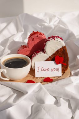 Tebrik kartında sabah kahvaltısı, ahşap tepside hediye paketinde Sevgililer Günü kutlaması, kalp şeklinde kruvasanlar. Puf böreği yeni moda tatlı pastanesi