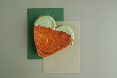 Lezzetli ve canlı kalp şeklinde hamur işi kruvasan. Renkli fındık şekeriyle kaplanmış. Şablon kopyalama alanı oluşturun. Gıda deneyleri viral tatlı yaratıcı pişirme eğilimi