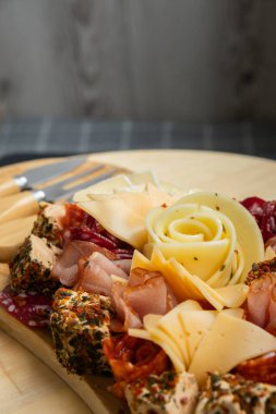 Peynir ve et şarküteri tahtası. Hediye hediyesi, öğle yemeği tabağı. Görsel olarak en az çaba gerektiren atıştırmalıklar. Özel peynir bıçaklarıyla basit bir yemek hazırlama. Tahta.