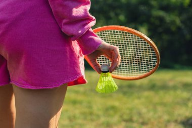 Tahta badminton raketleri ve oyuncak horozlarla oynayan tanınmayan bir kadın. Uzay yaz aktivitelerini kopyala. Konaklama boş zamanı