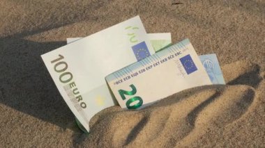 Para kumsalda 100, 20 euro. Tatil için para biriktirme kavramı. Seyahat tatillerinde maliyetli. Gölgeler