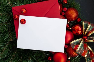 Kırmızı zarfla süslenmiş el yapımı Noel çelengi ve fotokopi alanı beyaz şablon kağıdı gibi. Kış bayramı tebrik kartı. en üstteki görünüm